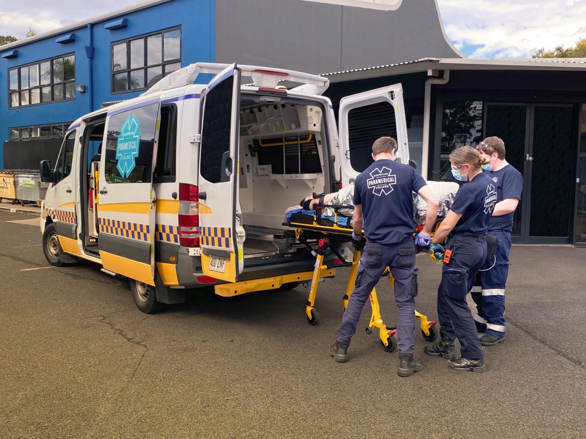 APC students putting stretcher in Ambulance